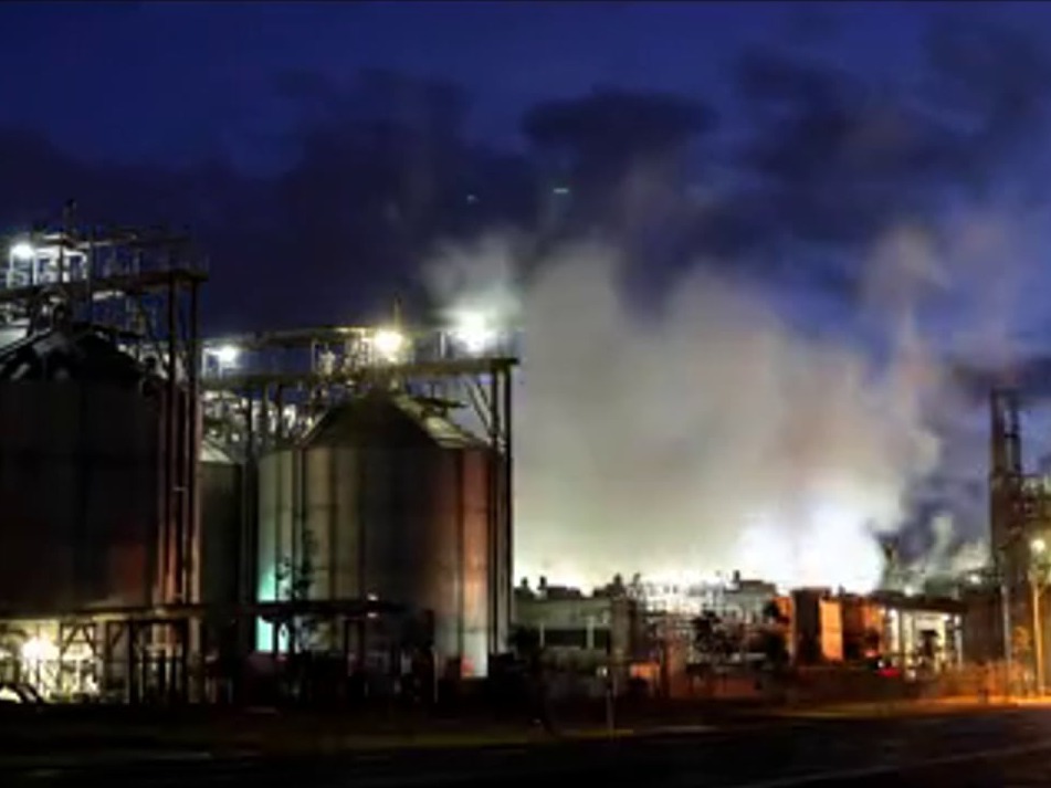 Manildra mill silos and steam plumes lit by floodlights at night