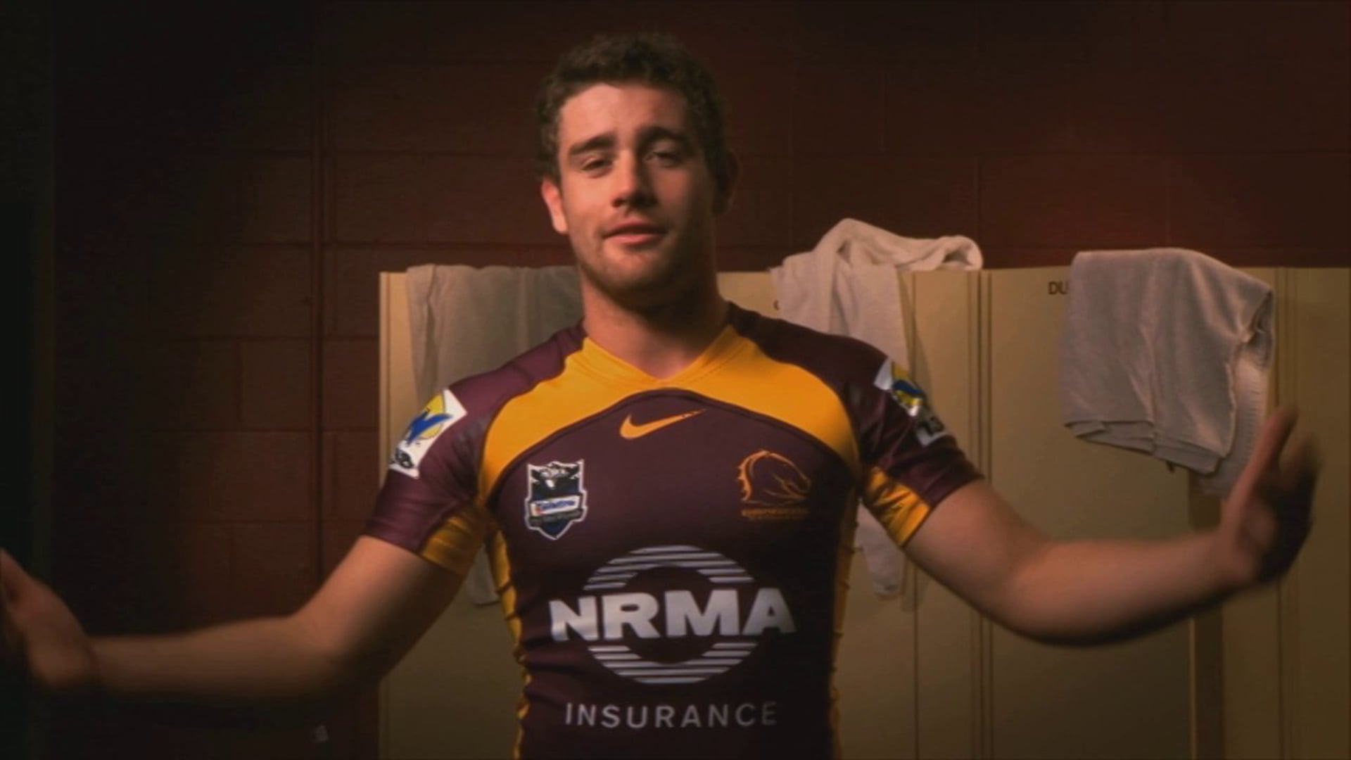 Rugby league player in a maroon and gold NRMA Insurance jersey in a locker room